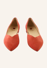 Czerwone zamszowe buty na szpilce z ostrym czubkiem, z wycięciem w kształcie V, niskim obcasem i beżowym wnętrzem z logo. Gładka tekstura bez widocznych wzorów.