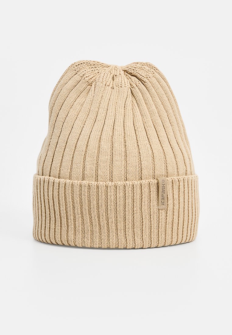 Beżowa dziana czapka z prążkowanym wzorem, z podwiniętym mankietem i małą metką z logo na boku. Miękki, elastyczny materiał odpowiedni na chłodne dni.