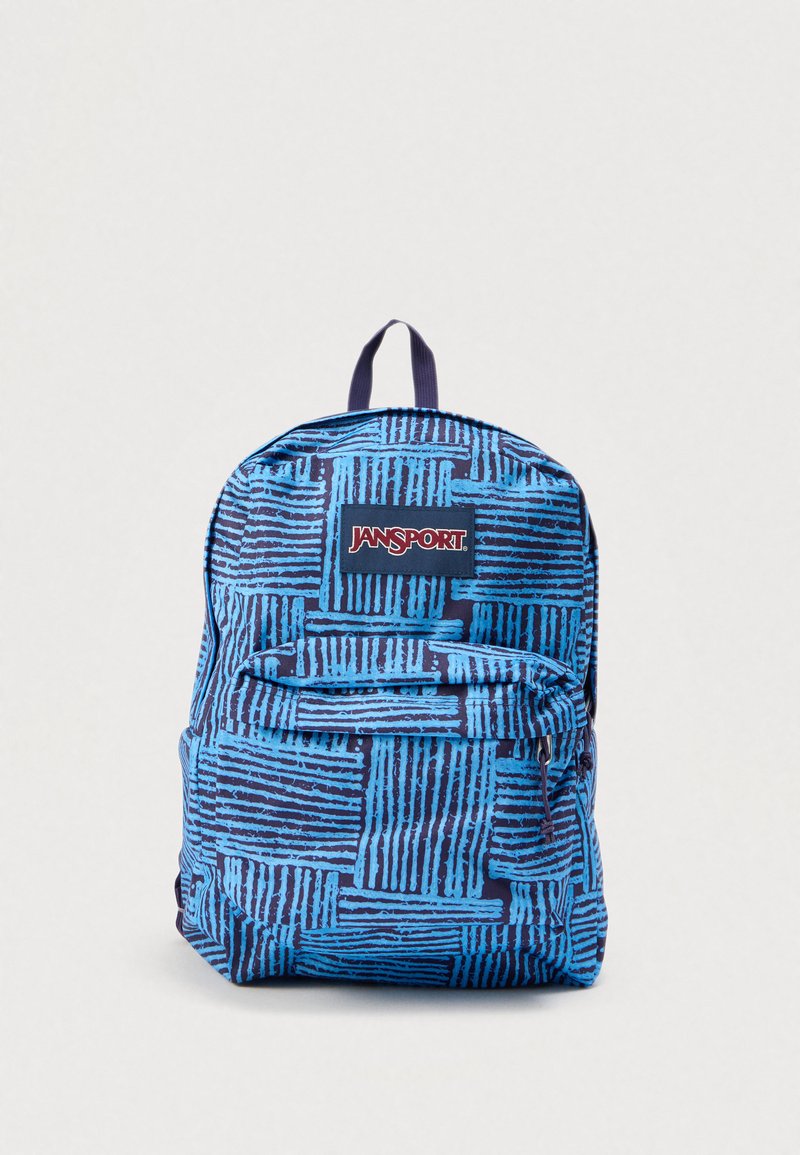 Modrý a tmavě modrý vzorovaný batoh Jansport s přední kapsou na zip a horním madlem na jednobarevném pozadí.
