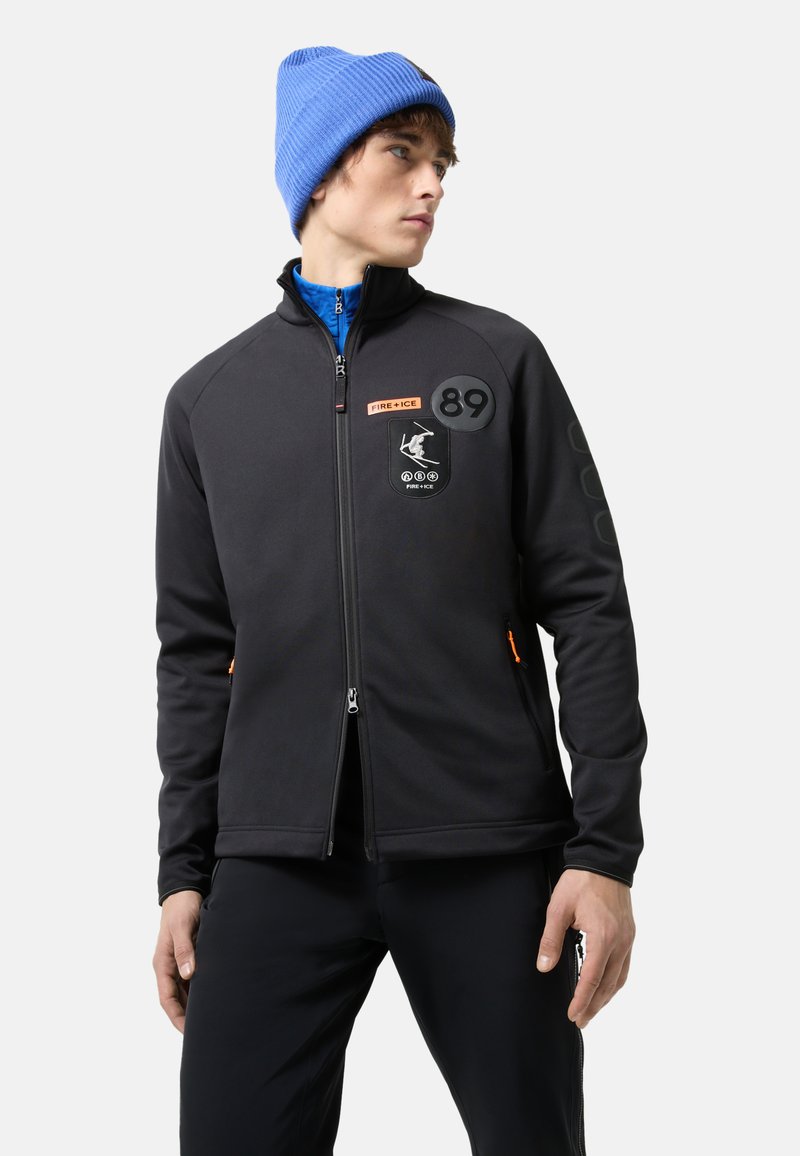 Black fleece jacket with orange accents, zippered front, logo patches, and ribbed collar. Worn with a blue knit beanie.