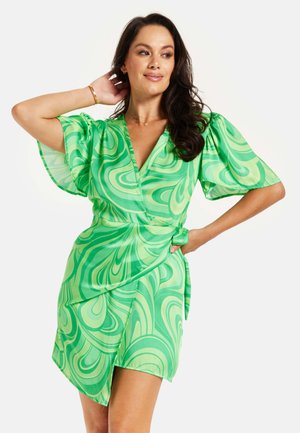 Green wrap dress with a swirl pattern, featuring short puff sleeves and a tied waist. Made of a lightweight, smooth fabric.