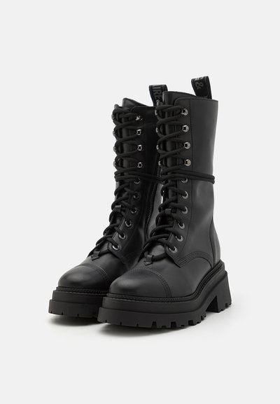 Black leather combat boots with high shaft, lace-up front, rugged sole, and metallic eyelets. Features a pull tab on the upper for easy wear.