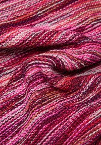 Strickstoff mit verschiedenen Streifen in Rosa-, Rot- und Weißtönen, mit einer weichen, strukturierten Oberfläche und sichtbaren Garn-Details.
