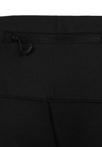 Gros plan d'un tissu noir avec une poche zippée horizontale comportant une petite languette et des coutures visibles sur la partie inférieure.
