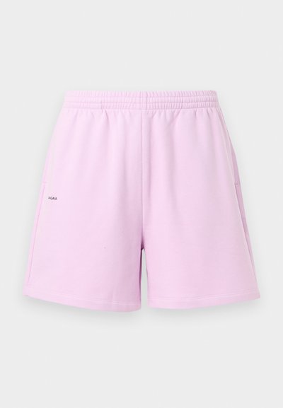 Lyse lilla shorts med elastik i taljen, sidelommer og lille sort logo på venstre side, vist mod en hvid baggrund.