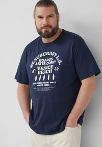 Navyblauwe katoenen t-shirt met witte tekst en graphics, korte mouwen, een relaxed fit en een ronde halslijn. De tekst omvat "Venice Beach."