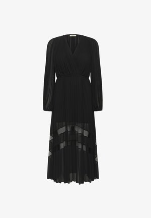 Juoda klostuota suknelė su ilgomis rankovėmis, V formos iškirpte ir liemens dirželiu. Permatoma apatinė sluoksnis su sluoksniuotomis raukšlėmis. Minkšta, plazdanti medžiaga.