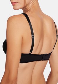 Svart trådlös bh med justerbara remmar och ett hak-och-öga-stängning på baksidan. Slät tyg med minimala sömmar.