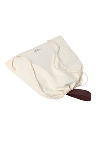 Bombažna vrečka s vrvico v krem barvi z rjavim usnjenim pasom. Vrečka ima zoženo odprtino in logotip na eni strani.