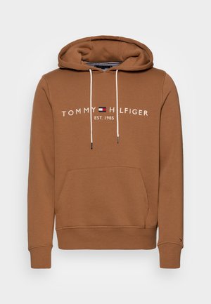 Brun hoodie med en kenguruficka, dragskohuv och vit broderad "TOMMY HILFIGER EST. 1985"-logotyp. Mjuk bomullsblandningsmaterial.