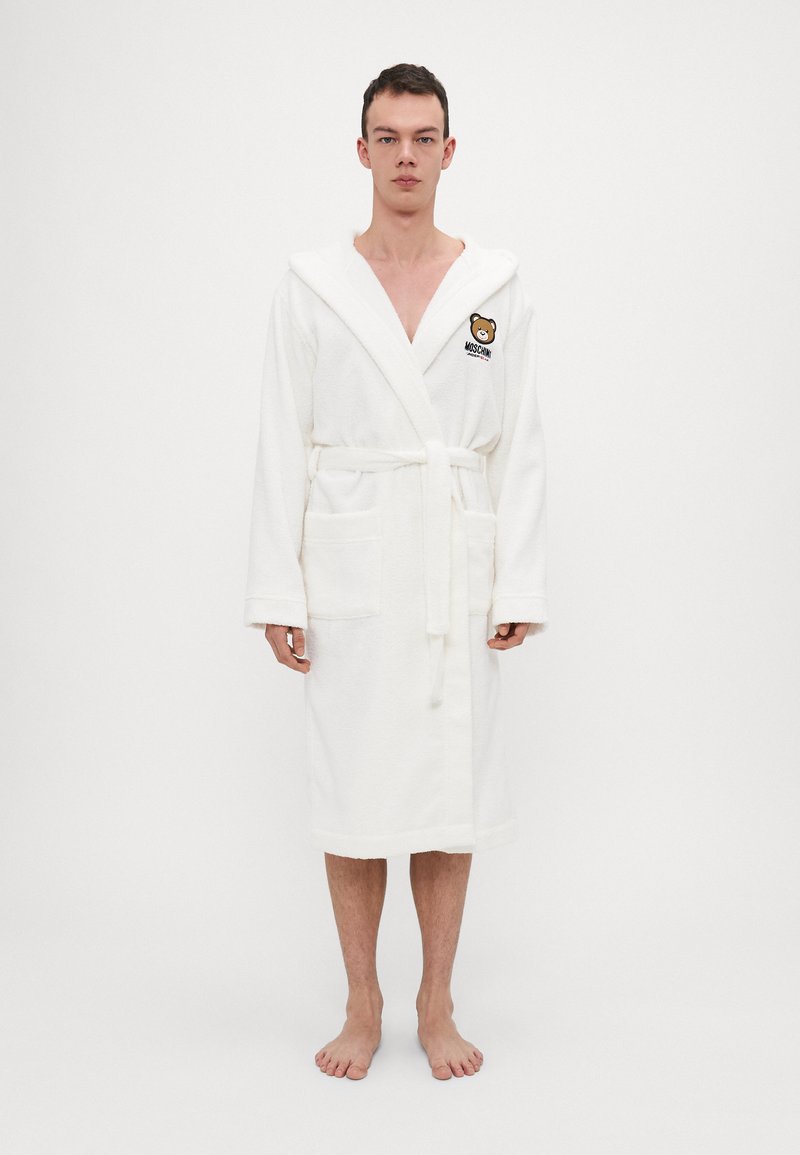 White terrycloth robe with hood, two front pockets, and a belt. Features an embroidered bear logo on the chest.