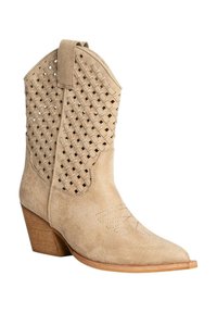 Bota de cowboy de ante beige con diseño trenzado en el costado, puntera afilada y tacón de madera apilada. Detalles bordados cerca de la puntera.