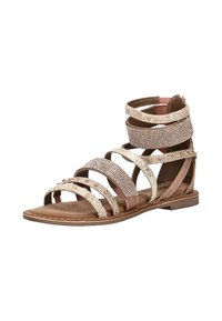 Płaskie sandały z wieloma ozdobnymi paskami, w tym z dżetami, ćwiekami i teksturowanym materiałem, w neutralnych odcieniach na brązowej podeszwie.