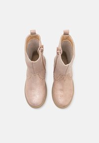 Botines metálicos rosas con un acabado suave, costuras decorativas y un cierre de cremallera lateral. Presentan una suela texturizada y un forro suave.