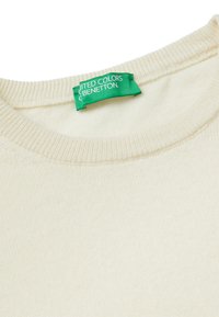 Cremiger gestrickter Pullover mit geripptem Rundhalsausschnitt und einem grünen United Colors of Benetton Etikett, das im Kragen eingenäht ist.