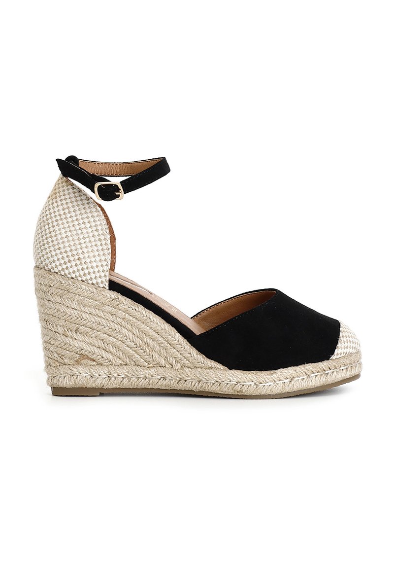 Espadrille con zeppa di suede nero e tacco in juta naturale intrecciata. Presenta una cinghia alla caviglia con una fibbia dorata e una parte superiore in tessuto beige texturizzato.