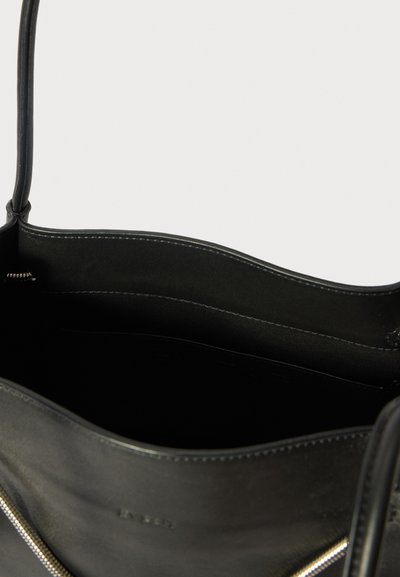 Borsa a mano in pelle nera con manico superiore, scomparto principale aperto e cuciture visibili lungo i bordi.