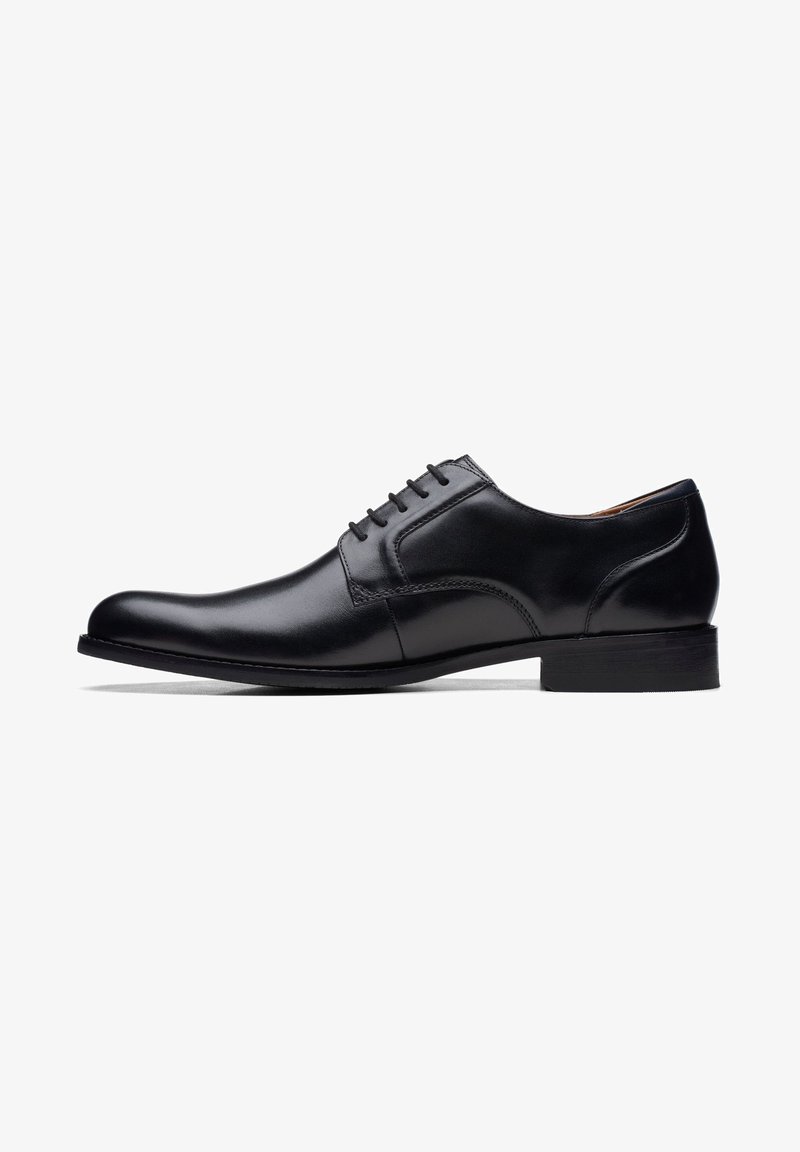 Schwarze Lederdressschuhe mit runder Zehenform, glatter Oberfläche, sechslöchrigem Schnürdesign und einem niedrigen, flachen schwarzen Gummihacken.