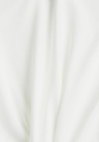 Tissu blanc à texture lisse, présentant un drapé doux et des plis subtils. Aucune motif ou accent visible.