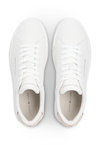 Λευκά αθλητικά παπούτσια με λείο επάνω μέρος από συνθετικό δέρμα, επίπεδα κορδόνια, επένδυση στο κολάρο και αντίθετη μπεζ λεπτομέρεια στη φτέρνα. Διαθέτουν λογότυπο της μάρκας στο πλάι.