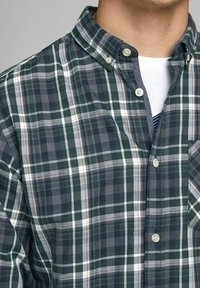 Groen-grijs geruit overhemd met knopen en een kraag, voorzien van een borstzak en gemaakt van zachte katoenen stof met contrasterende witte strepen.