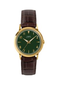 Hodinky Timex Marlin se zlatým pouzdrem, tmavě zeleným ciferníkem a hnědým koženým řemínkem s krokodýlím vzorem. Mají zlaté hodinové indexy a ručičky.