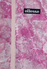 Tela de patrón de mármol rosa con un cierre vertical y un logotipo bordado en negro de "ellesse" sobre un fondo blanco.