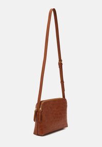 Brown crocodile-embossed leather crossbody bag with a thin adjustable strap and dual gold-tone zip closures. Smooth texture and sleek design.