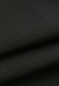 Zwarte ribstof met een gladde textuur, voorzien van subtiele rek en een gelijkmatige weefstructuur, gevouwen om de diepte en rijkdom ervan te laten zien.