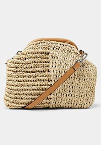 Sac bandoulière beige tissé avec bandoulière en cuir marron clair et bordure supérieure, présentant une texture tricotée épaisse et une quincaillerie métallique argentée.