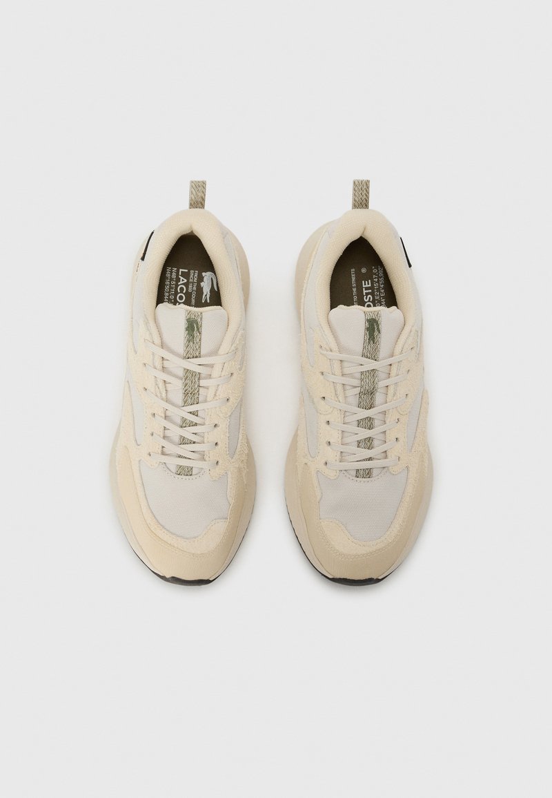 Scarpe sportive beige con tomaia in rete e suede, lacci piatti, dettagli testurizzati e suola in gomma con particolari a contrasto.