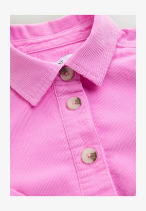 Rózsaszín kordbársony ing klasszikus gallérral és három kerek gombbal, texturált anyaggal és jól látható varrási részletekkel.