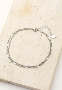 Pulsera de múltiples hilos en plata que presenta varios estilos de cadena, acentos rectangulares, un cierre de langosta y una cadena de extensión con un charm.