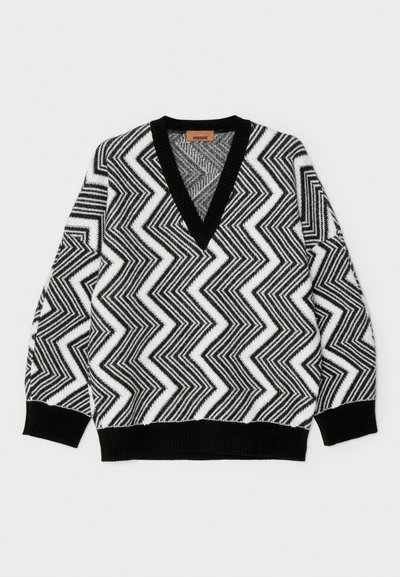 Črno-bela pulover z zigzag vzorcem, z globokim V-izrezom, rebrastimi manšetami in robom, narejen iz teksturirane pletenine.