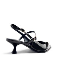 Sandalo con tacco in pelle laccata nera, con cinturini incrociati, punta aperta e design unico del tacco svasato. Presenta dettagli in metallo color oro.