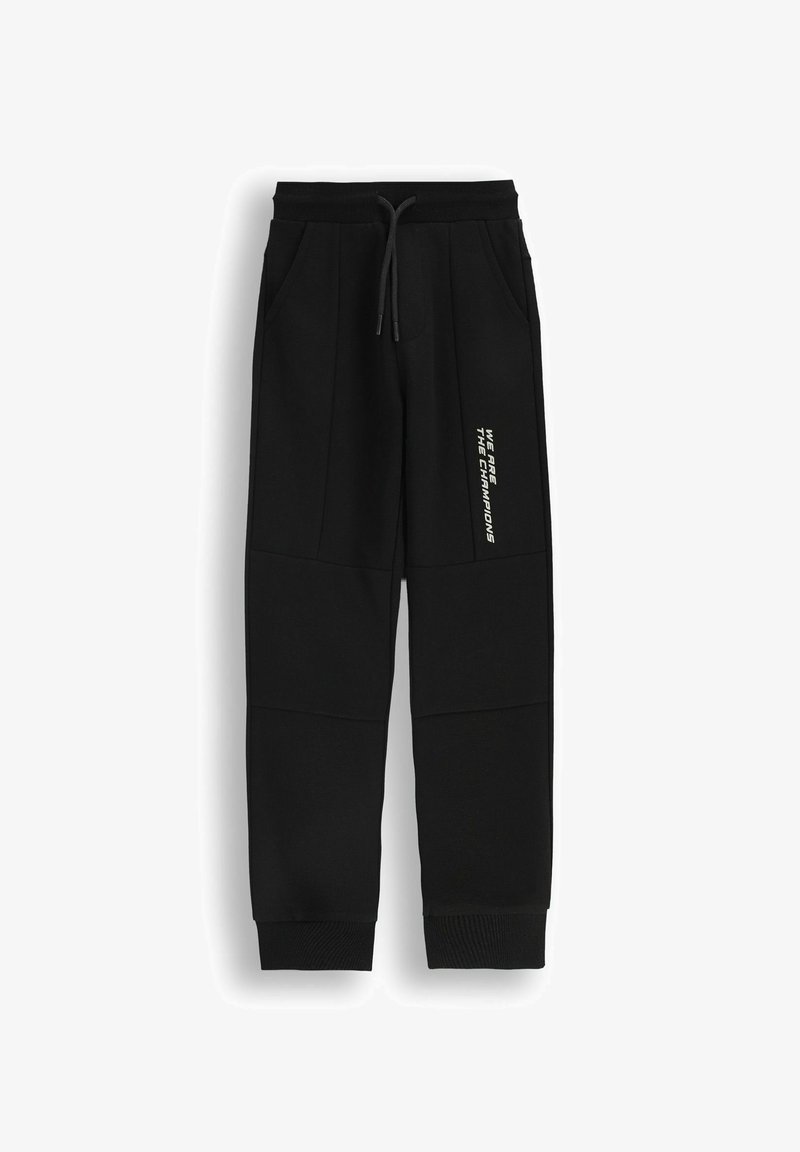 Czarne dresy z miękkiego materiału, z bocznymi kieszeniami, elastycznym pasem na sznurki i nadrukowanym hasłem na nodze. Żebrowane mankiety.