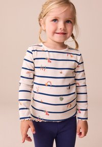 Gestreiftes langärmeliges Hemd in Creme mit marineblauen Streifen, verziert mit bunten Mustern von Tieren und Gemüse. Weiche, gerippte Textur, geschwungener Saum.