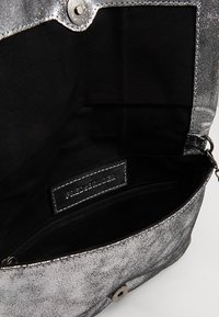 Borsa metallizzata argento con texture liscia, chiusura magnetica e interno in tessuto nero con tasca con cerniera.