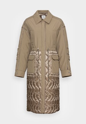 Manteau long beige avec moitié inférieure matelassée, taille cintrée avec cordons, deux poches à rabat à l'avant, manches longues et col.
