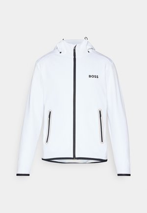 Veste blanche avec capuche, fermeture éclair noire et accents, deux poches latérales zippées et logo "BOSS" sur la poitrine. Tissu lisse et léger.