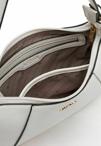 Weiße Lederhandtasche mit strukturierter Form, ausgestattet mit einem Reißverschluss, braunem Innenfutter mit Taschen und einem dezenten eingeprägten Muster.