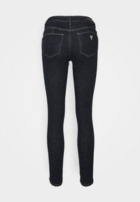 Smala jeans i mörk denim, med midja som sitter i midjehöjd, bakfickor och kontrasterande sömmar. Slät textur med minimalt med beslag.