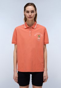 Koralli polo-paita, jossa on kahden napin napitus, valkoinen kaulusreunus ja brodeerattu palmupuun kuvio. Lyhyet hihat ja pehmeä Texture.