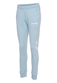 Lyseblå sweatpants lavet af blødt stof, med et hvidt logo og accentstriber langs siderne. Elastisk talje og manchetter.