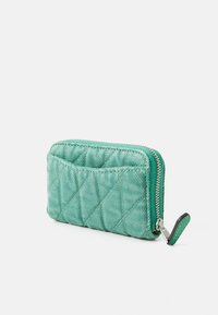 Quilted green wallet in textured material with a diagonal pattern, a zippered closure, and a contrasting green zipper pull.