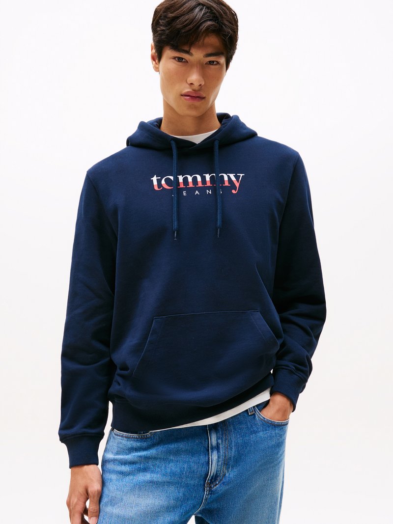 Felpa navy in cotone misto con tasca frontale a canguro, caratterizzata dal logo bianco "tommy" sul petto e cappuccio con cordoncino.