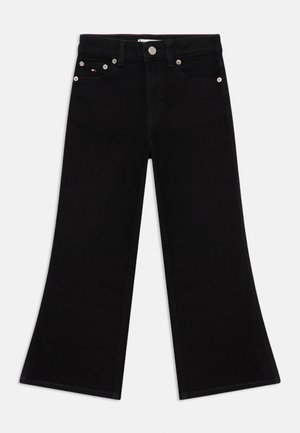 Sorte flared jeans laget av denim. Har fem lommer, sølvfarget detaljer og røde sømmer på innsiden av livet. Flat front og brede benåpninger.
