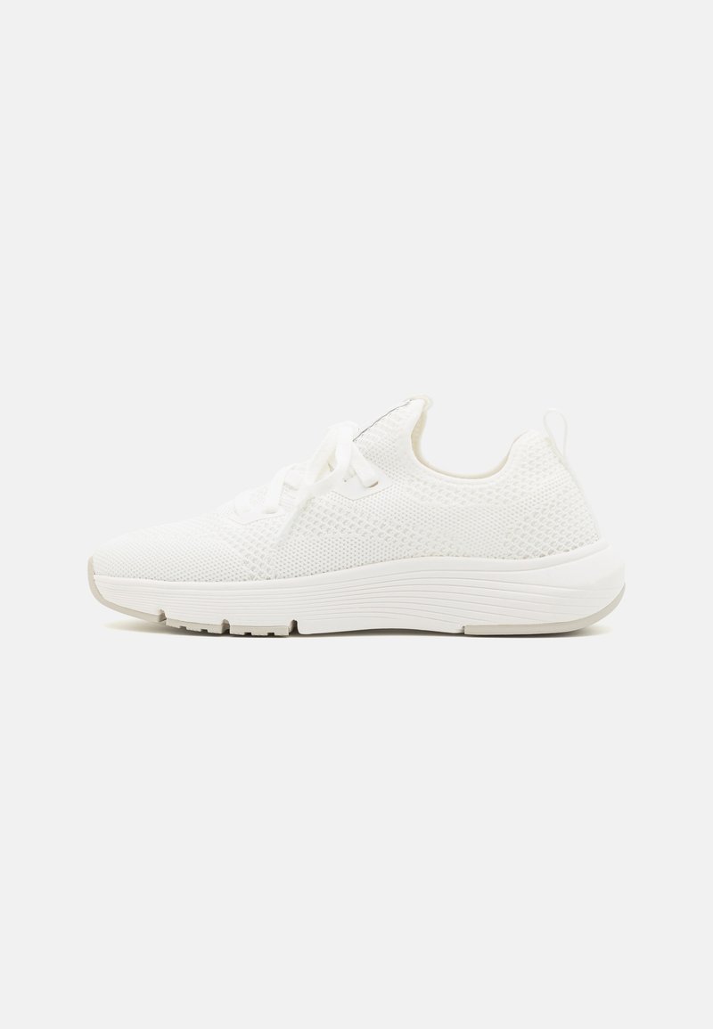 White athletic shoe with a textured knit upper, round toe, flat lace closure, and a thick sole featuring a subtle tread pattern.
