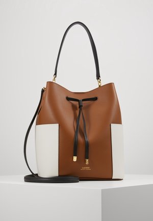 Sac seau en cuir marron avec des panneaux latéraux blancs, cordon noir et poignée, présenté sur une surface blanche.