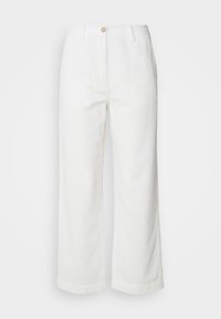 Pantalon large blanc en tissu texturé avec un motif côtelé, doté d'une fermeture à bouton à l'avant et de poches sur les côtés.